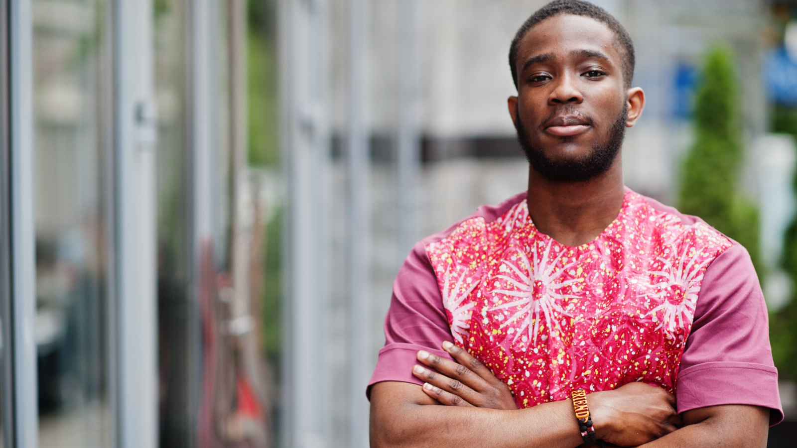 Portrait of a black young man wearing african traditional red colorful clothes.