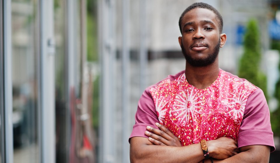 Portrait of a black young man wearing african traditional red colorful clothes.